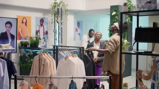 商场的零售助理使用Ar技术向顾客展示便宜和可持续的服装 在环保二手商店用增强型全息图拍摄员工多莉 — 图库视频影像