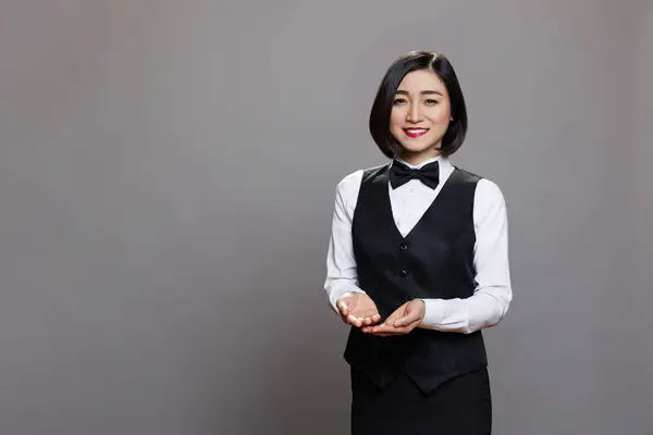Smilende Asiatisk Professionel Servitrice Viser Med Hænderne Mens Man Ser - Stock-foto