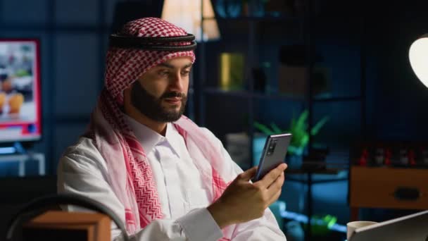 インターネット上のビデオ会議中に親しい友人をチェックする笑顔のアラブの男 ハッピー中東の人は オンラインビデオ通話セッションで友人と一緒に時間を楽しんでいます — ストック動画