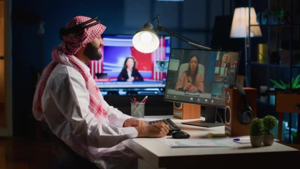 アラビアのマネージャーがリモートで作業するサブターンでオンラインビデオ会議を開催します スタイリッシュなアパートでデスクに座って ビデオ通話中に労働者と話し合うテレワーキング会社の幹部 — ストック動画