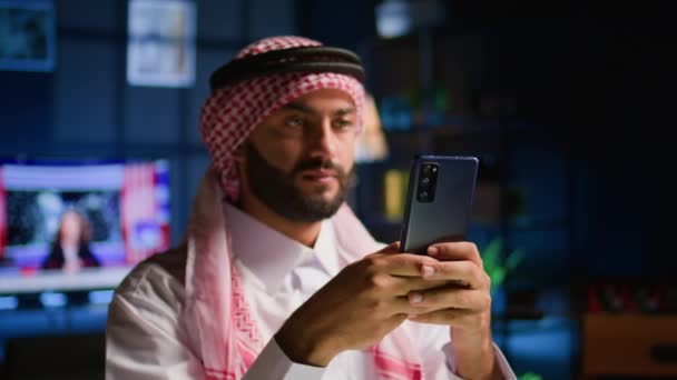 Портрет Счастливого Арабского Телеработника Отправляющего Текстовые Сообщения Друзьям Стильную Квартиру — стоковое видео
