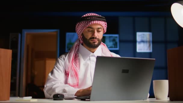 阿拉伯员工专注于完成重要的工作任务 从时尚公寓的私人办公室远程工作 集中在笔记本电脑键盘上的穆斯林远程工作者打字 — 图库视频影像