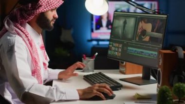 Yapım sonrası projeyi düzenlerken kulaklık takan ses editörü, ses kalitesini yükseltiyor. PC çalışma istasyonundaki görüntülerde değişiklik yapmak için profesyonel yazılım kullanan adam