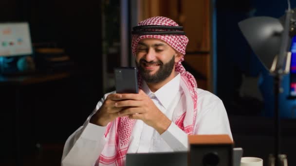 Glad Arabisk Man Hemma Vardagsrummet Skriva Meddelanden Smartphone Mellanösterns Person — Stockvideo