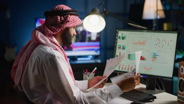 在时尚公寓里远程工作时 阿拉伯的远程工作者会检查分析数据集 以电视为背景噪声优化关键绩效指标的业务经理 — 图库视频影像
