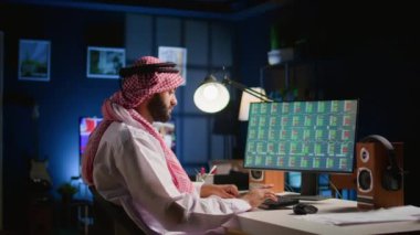 Kişisel ofis masasındaki Müslüman broker yatırımcısı hisse senedi değerleme mali kar rakamlarını kontrol ediyor. Arap tele çalışan hissedar işadamı pazar payı artışına bakıyor, yakın plan