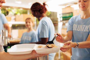 Daha az ayrıcalıklı evsizlere ve yerel merkezdeki mültecilere bedava yiyecek ve yardım dağıtmak için işbirliği yapan çok ırklı bir gönüllü grubu. Kadın gönüllüler muhtaçlara yardım ve yemek servisi yapıyor..