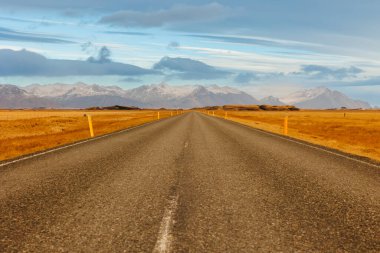 Kuzey Kutbu çevresi, İzlanda bölgesinde uzun yol konsepti ve otoyol. Kuzeydeki cennette büyük bir dağ sırası ve yol var. İnanılmaz kırsal alanlar yol kenarında..