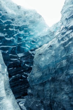 Vatnajokull glacier frosty caves in iceland, transparent ice blocks in wintry icelandic landscape. Inside icy crevasse with covered frost and snow, massive icebergs in arctic scenery. Glacier hiking. clipart
