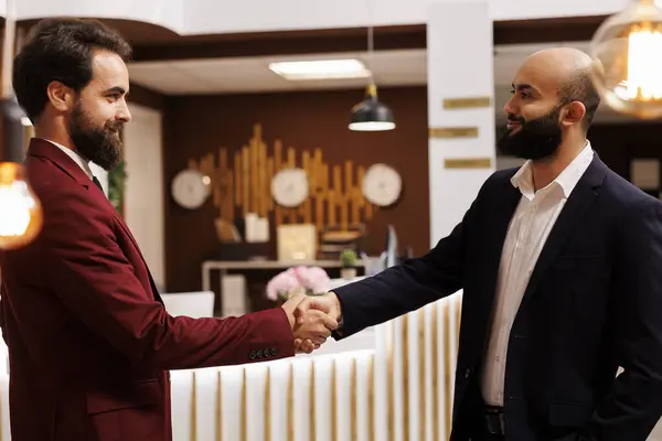 Business partners agreeing on collab, travelling for work to attend important corporate meeting. Two executive managers shaking hands in agreement to start fruitful partnership.