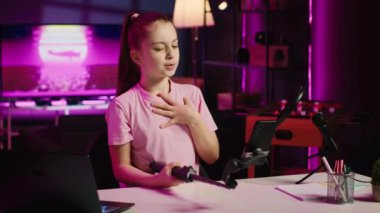 Gen z young, internet kanalı için selfie çubuğuna bağlanmış telefonuyla video çekiyor ve izleyicilerle konuşuyor. Çocuk, gelecek kliplerde, el kamerasında görmek istediği konuları izleyiciye anlatıyor.