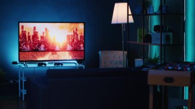 Boş stil neon ışıklı ev stüdyosu geceleri neon ışıkları ve duvarları dekore eden sanat eserleriyle aydınlatılıyor. Haber kanalında arka planda televizyonu olan modern bir daire.