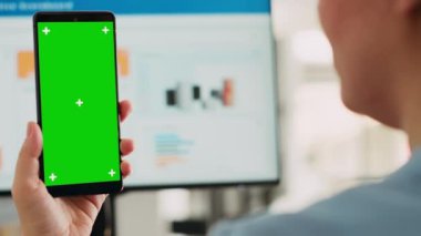 İş adamı masasında yeşil ekran cihazı tutuyor, çalışma alanındaki boş model görüntülere bakıyor. İzole edilmiş kromakey şablonu, ekran düzeni gösteren cep telefonu gösteren bir kadın. Kapat..