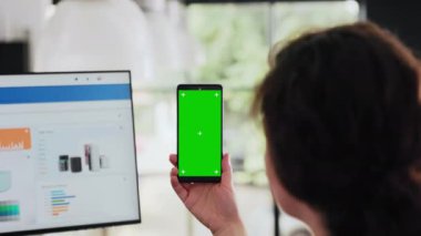 İşçi, iş merkezindeki iş yerinde oturan yeşil ekranlı telefonu inceledi. Kopya uzay düzeniyle boş kromatuvar görüntüsünü analiz etti. İnsan akıllı telefondan çalışır. El kamerasıyla. Kapat..