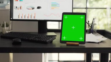 Mobil cihaz ekranında izole edilmiş kromakey dizaynını gösteren, iş ortaklaşa çalışma alanındaki modern tablette yeşil ekranlı bir masa. Kopyalama alanı olan boş ofis çalışma istasyonu aygıtı.