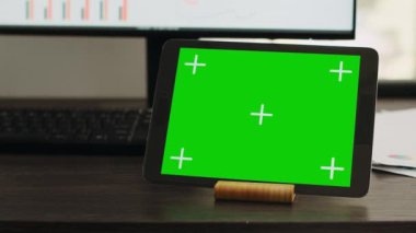 İş ortaklaşa çalışma alanı tabletinde yeşil ekranlı boş masa, modern cihaz ekranında izole edilmiş telif alanı düzeni. Kromakey model ekranı gösteren aygıtlı çalışma istasyonu.