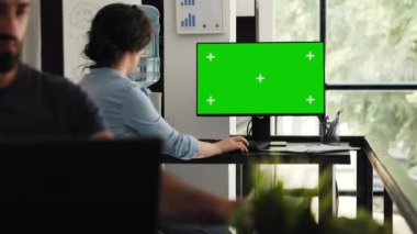 İş kadını çalışma alanındaki çalışma masasında masaüstünü yeşil ekran ile inceliyor, kromatonlu ve izole ekran kullanan bir bilgisayar kullanıyor. Şirket çalışanı boş telif alanı monitörünü inceliyor.
