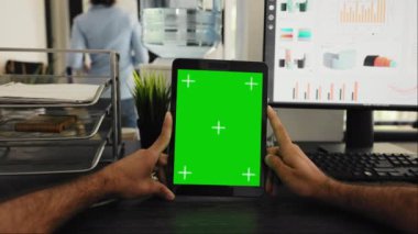 Yeşil ekran şablonlu iş adamı POV 'u, kromakey ekrana ve birlikte çalışan uzay masasına bakıyor. Aygıt ekranında izole edilmiş kopyalama alanını inceleyen kişi.