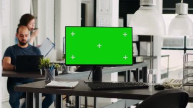Ofisteki bilgisayar üzerindeki yeşil ekran şablonu, modern bilgisayar çalışan ajanslarla birlikte çalışma alanında izole edilmiş kromakey görüntüler gösteriyor. Monitörde boş model ekran, boş masa.