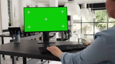 Çalışma masasında oturan yeşil ekran monitörde, birlikte çalışma alanındaki bilgisayar masaüstü izole edilmiş telif alanı düzenine bakıyor. İş kadını bilgisayar üzerinde çalışıyor, boş model şablonu.