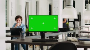 Modern çalışma alanındaki boş bir masada yeşil ekranlı monitör, pc kopyalanmış maket şablonu görüntülüyor. Küçük işletme işlemleri için kullanılan kromakey ekran aygıtı. Üçayak atışı.