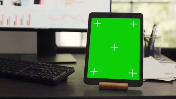 エージェンシーのコワーキングスペースのタブレットに緑色のワークステーション モバイルデバイスディスプレイ上の隔離された染色体テンプレートを実行します 空白のコピースペースレイアウトでガジェットを表示する空のオフィスデスク — ストック動画