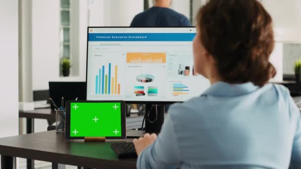 办公室工作人员检查平板电脑上的绿屏显示 使用独立的复制空间模板处理业务操作 并分析案头计算机上的数据 带着玩具娃娃 — 图库视频影像