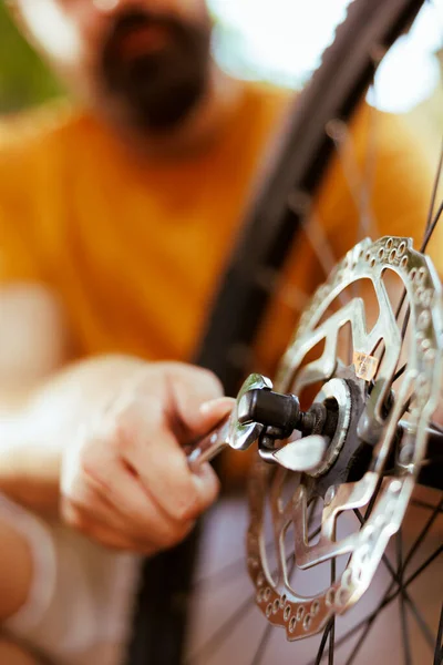 用院子里的专用扳手进行人员紧固和固定自行车链条环的特写 使用专业工具维修室外自行车零件的详细图像 — 图库照片