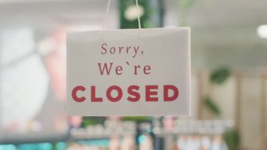 Moda mağazasının kapısında müşterilerin dükkanın kapalı olduğunu bildiren son derece yakın plan bir fotoğraf. Üzgünüm, kapalıyız. Boş çevre dostu ikinci el giysi mağazası tabelası.