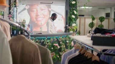 BIPOC çalışanı şık spor ceketlerle lüks giyim mağazasında çalışıyor. Afro-amerikan esnaf müşterilerini şık giysileri olan özel moda mağazasında bekliyor.