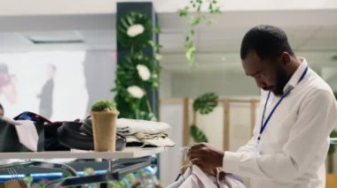 Son trendleri takip ederek alışveriş merkezindeki giyim mağazasında hızlı moda kıyafetleri ayarlayan zarif bir işçi. Moda butiğinde şık erkek ceketlerinin çeşitli organizasyonlarını yapan titiz bir esnaf.