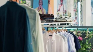 Son moda kıyafetleri ile alışveriş merkezindeki boş giyim mağazası. Modern, temiz moda butiğinde müşterileri bekleyen şık erkek gömlekleri, pantolonları ve kemerleri.
