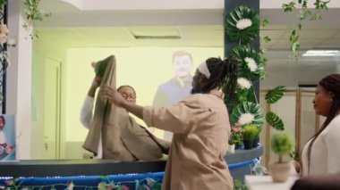 BIPOC kasiyeri, gişedeki ikinci el dükkanında sırada bekleyen müşteriler için işlem yapıyor. Tecrübeli çalışanlar ikinci el dükkanından alışveriş yapanlara yardım ediyor.