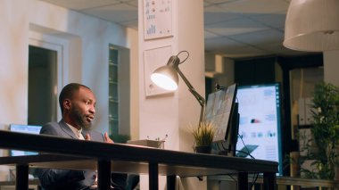 Çalışanlar iş kıyafetleri giyer ve başka bir bölümden şirket yöneticileriyle çevrimiçi video görüşmesi yapar. Muhasebeci telekonferans toplantısı sırasında iş arkadaşlarıyla sohbet ediyor.