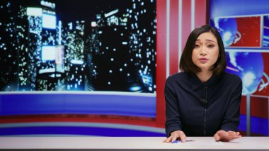 Stüdyoda gece yarısı talk show sunucusu, TV programından canlı yayın yapıyor. Sunucu kadın tüm ünlü konuları ve önemli medya olaylarını kapsayacak şekilde gece yarısı haber bültenini sunuyor..