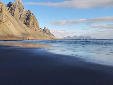 Doğal stoksnes siyah kum plajı büyük vestrahorn dağ zinciri görkemli İzlanda manzarası yaratıyor. Buz Diyarı manzaralı yarımadada kayalıkları olan inanılmaz okyanus kıyısı.