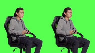 Yeşilperde arkaplanı üzerinde yarışan, joystick ile video oyunları oynayan biri. Genç Asyalı adam çevrimiçi oyun yarışmasından hoşlanıyor, yetenekli video oyunu oyuncusu.