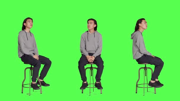 Mladý Dospělý Sedí Židli Čeká Něco Studiu Dívá Hodinky Hledá — Stock video