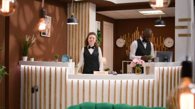 İşçi, müşterileriyle telefon görüşmesinde online rezervasyon talebinde bulunuyor. Beş yıldızlı otelde resepsiyon görevlileri yeni misafirleri karşılamak için telefon kullanır..