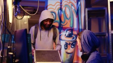 Gizli yeraltı üssündeki Afrikalı Amerikalı hacker, iş arkadaşı SSD 'ye, bilgileri olmadan kullanıcı bilgisayarlarından bilgi toplamak için kullanacakları virüsü göstermek için heyecanlı.