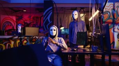 Hacker grubu üyeleri online terörizm eylemleri yapıyor, gizli yeraltı üssünde akıllı telefonla fidye videosu çekiyor, ödeme talepleri karşılanmazsa çalınan hassas verileri alenen yayınlamakla tehdit ediyorlar.