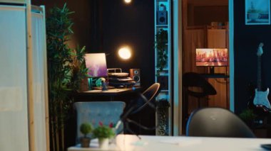 Bilgisayar ekranları, loş ışıklandırılmış boş ev içini gösteren animasyonu gösteriyor. Ev bitkileriyle dolu, neon ışıklı, rahat bir apartman dairesinde dijital ekranlarda 3D görüntüler
