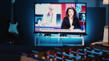 Gece açık bırakılan televizyonun yakın plan görüntüleri, haber yayınlarını gösteren loş bir apartman dairesinde. Ev yapımı eğlence sistemi oturma odasında televizyon raporlarını gösteriyor.