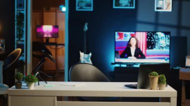 Boş ev stüdyosunun iç çekimleri gece aydınlatmalı ve internet video yapımında kullanılıyor. İçerik oluşturma ekipmanlarıyla dolu daire, arka planda çalışan TV