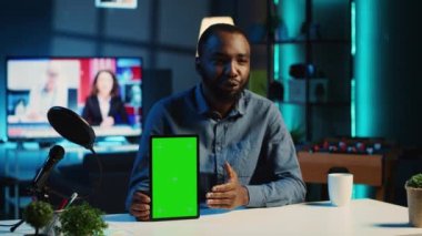 Teknoloji içeriği üreticisi yeşil ekran tabletini boks yaparken çekiyor ve satın almak için nedenler sunuyor. Nüfuz Edici, aboneleri sponsor partner modelleme dijital aygıtı satın almaya teşvik eden video kaydı yapıyor