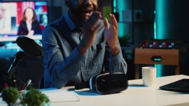 İçerik yaratıcısı, VR kulaklığı incelemesini kaydediyor, paketleri açıyor ve çevrimiçi platformda izleyicilere özelliklerini sunuyor. Sanal gerçeklik gözlüklerini abonelere gösteren viral internet yıldızı