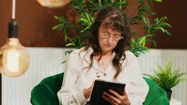 Ηλικιωμένη Γυναίκα Κάθεται Καναπέ Tablet Πολυτελές Σαλόνι Περιμένοντας Δωμάτιο Check — Αρχείο Βίντεο