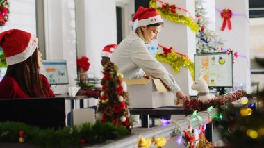 Pissed employee packs desk belongings and steals Christmas office ornaments on last day at work to feel better. Vengeful woman getting fired from job during layoffs, delighted about retribution