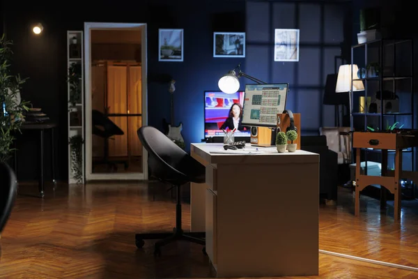 An empty newly opened workplace in a contemporary style is seen at night with desktop graphics active. A modern firm with no employees a new office layout indoor workspace.