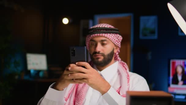 Leende Arabiska Mannen Hemma Vardagsrummet Skriva Meddelanden Smartphone Mellanösterns Person — Stockvideo